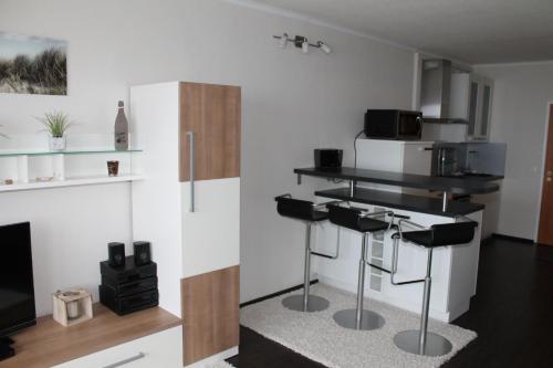 a living room with two bar stools and a tv at Ferienappartement K1102 für 2-4 Personen mit Weitblick in Brasilien