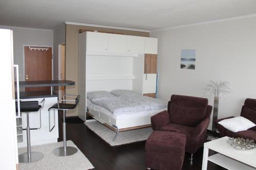 ブラズィリアンにあるFerienappartement K1102 für 2-4 Personen mit Weitblickのベッドルーム(ベッド1台、ソファ、椅子付)