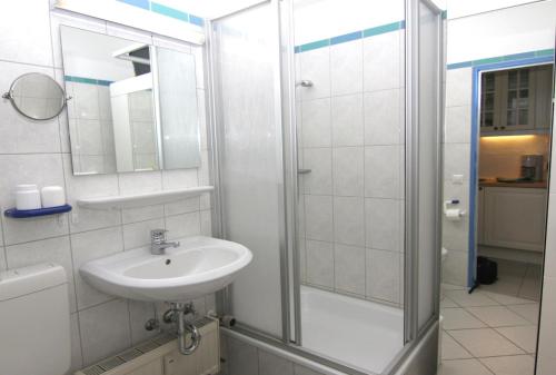 uma casa de banho branca com um lavatório e um chuveiro em Ferienappartement K1213 für 2-3 Personen mit Ostseeblick em Brasilien