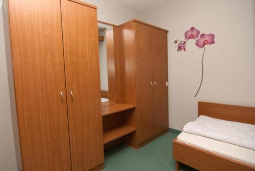 ブラズィリアンにあるFerienappartement K1402 für 2-4 Personen mit Ostseeblickのベッドルーム(木製キャビネット、ベッド1台付)