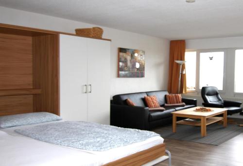 ブラズィリアンにあるFerienwohnung K1414 für 2-4 Personen mit Ostseeblickのベッドルーム1室(ベッド1台、ソファ、テーブル付)