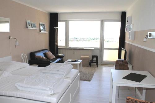 1 dormitorio con 1 cama, 1 silla y 1 mesa en Ferienwohnung K1409 für 2-4 Personen mit Ostseeblick, en Brasilien
