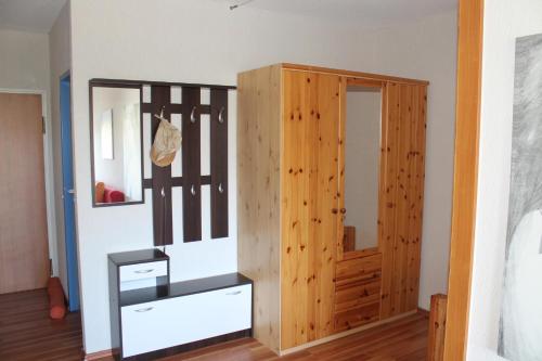 ブラズィリアンにあるOstsee-Ferienapartement K217 für 2-4 Personenの木製のクローゼットと木製のドアが備わる客室です。