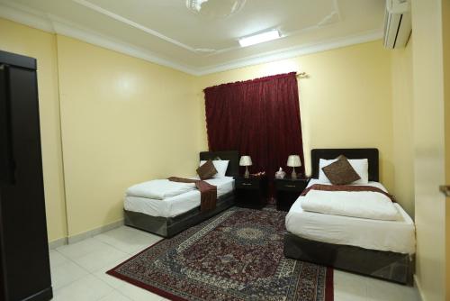 a hotel room with two beds and a rug at العيرى للشقق المخدومه جازان 1 in Jazan