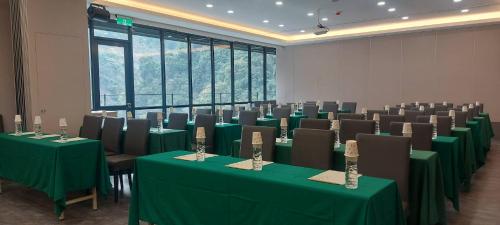 a conference room with green tables and chairs at Tangyue Resort in Taian