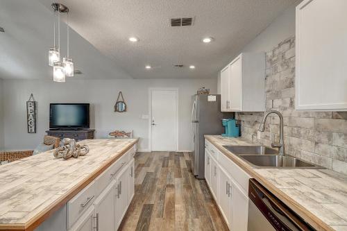 una cocina con fregadero y refrigerador en Mermaid's Landing, en Rockport