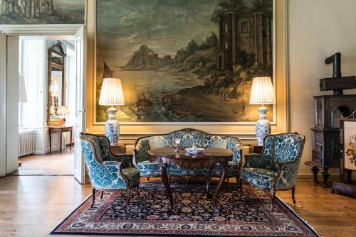 a living room with a table and chairs and a painting at Skjoldenæsholm Slot in Jystrup