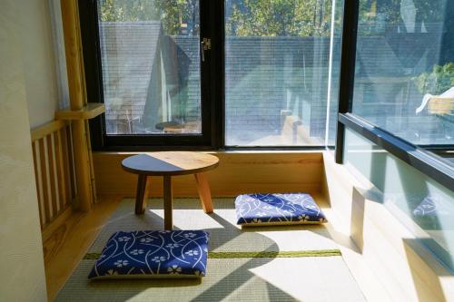 a room with a table and a stool in front of a window at Tangyue Resort in Taian