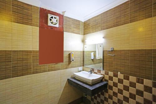 Hotel Ambrosia - A Boutique Hotel في نيودلهي: حمام مع حوض ومرآة