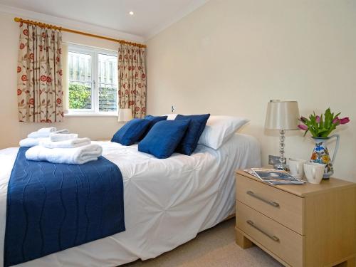 a bedroom with a large white bed with blue pillows at Havens Rest in Walton West