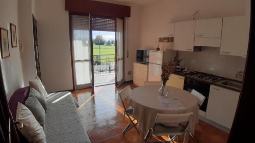 sala de estar con mesa y cocina en Villa Gaudi, en Cornegliano Laudense