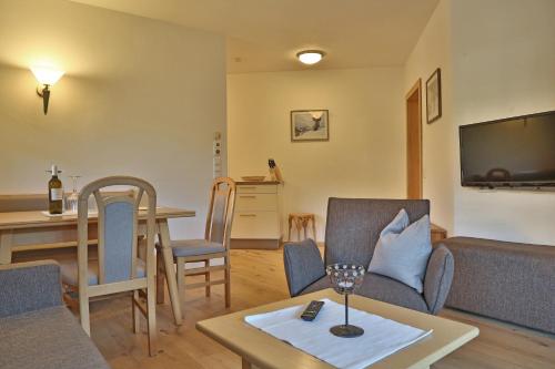 a living room with a couch and a table at Landhaus Schneider in Fieberbrunn