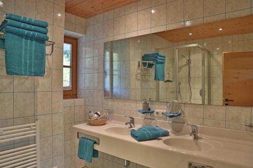 ein Bad mit einem Waschbecken und einem Spiegel in der Unterkunft Landhaus Schneider in Fieberbrunn
