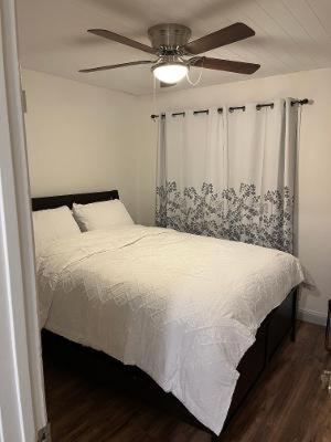 a bedroom with a bed with a ceiling fan at Private Room in Rialto in Rialto