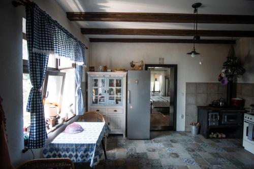 eine Küche mit einem Tisch und ein Zimmer mit einem Schlafzimmer in der Unterkunft Petershaus - casa de vacanța și distractie. 