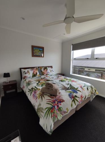 una camera da letto con un letto con copriletto floreale e una finestra di Modern House near Motuoapa Tongariro Crossing fishing skiing a Turangi