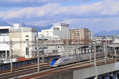 pociąg na torach w mieście z budynkami w obiekcie Hotel Metropolitan Takasaki w mieście Takasaki