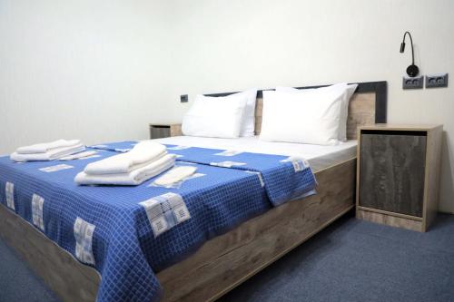 Un dormitorio con una cama azul y blanca con toallas. en SAFAR hotel, en Tashkent