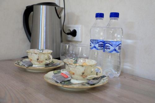 Dos botellas de agua y dos tazas en una mesa. en SAFAR hotel, en Tashkent