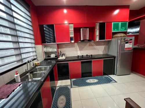 a kitchen with red and green cabinets and a refrigerator at Pa&Ma HomeStay Kulim 4R3B fully aircond in Kulim