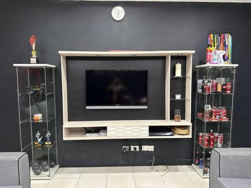 a entertainment center with a television on a wall at Pa&Ma HomeStay Kulim 4R3B fully aircond in Kulim