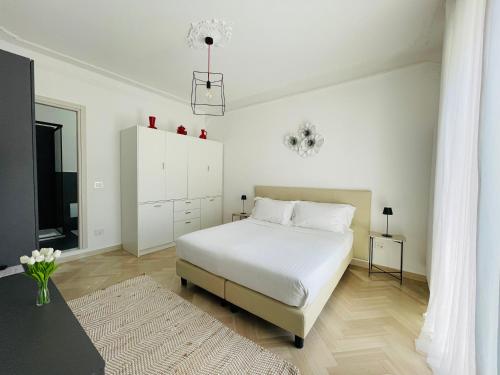 a white bedroom with a bed and a table at Casa Rafanelli in Monforte dʼAlba