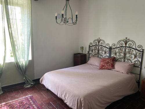 a bedroom with a bed and a chandelier at B&B Ostria Vento in Medesano