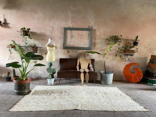 a mannequin sitting on a couch in a room with plants at B&B Ostria Vento in Medesano