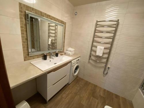 a bathroom with a sink and a washing machine at Atlant luxury Big Family Perlina Apart on Golovna з двома санвузлами поряд з ТЦ Депот in Chernivtsi