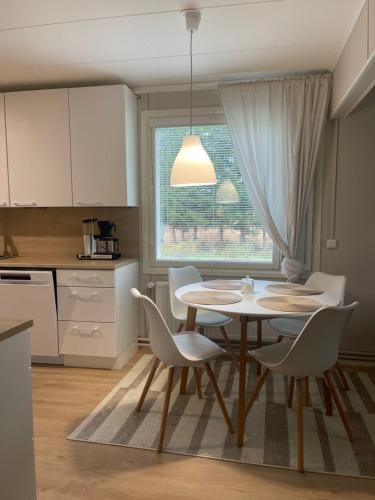 uma cozinha com mesa e cadeiras e uma janela em Pieni omakotitalo joen rannalla em Rautio