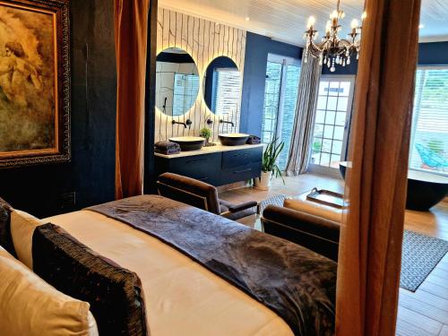 a bedroom with a large bed and a bathroom at PJURE Wellness Retreat & Spa in Montagu