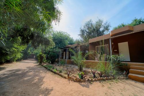 a house with a dirt road in front of it at Tiger Machan in Sawāi Mādhopur