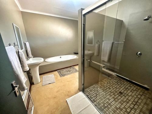 a bathroom with a shower and a toilet and a sink at Lake Grappa Guestfarm in Augrabies