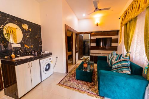 a living room with a blue couch and a kitchen at The Roma Homestay in Sarnath Varanasi in Varanasi