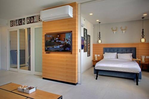 a bedroom with a bed and a television in a room at דירת נופש באכזיב עם ג'קוזי מול חוף בננה ביץ Dream Place Achziv in Nahariyya