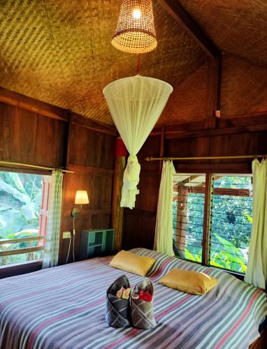 a bedroom with a bed with two bags on it at Pencave Homestay in Pang Mapha