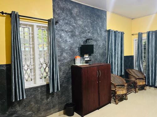 a living room with a tv and a window at Maharaja Cottage in Munnar