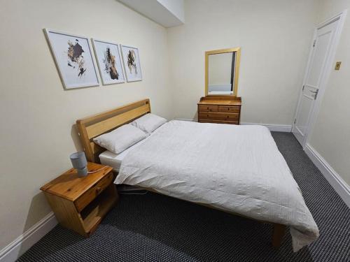 a bedroom with a bed and a dresser and a mirror at Cheerful Home near Preston train station & Uclan in Preston
