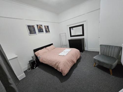 a bedroom with a bed and a chair at Cheerful Home near Preston train station & Uclan in Preston