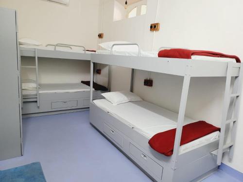 Zimmer mit Etagenbett und weißen Etagenbetten in der Unterkunft Jambul House in Panaji