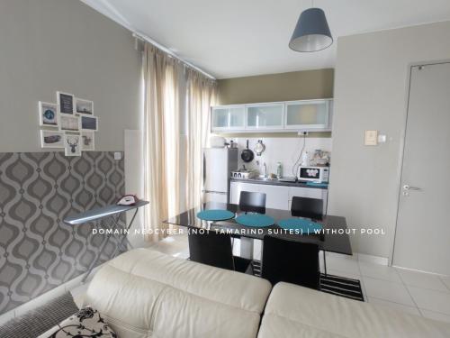 a living room with a white couch and a kitchen at Tamarind Suites or D'Pulze Residence or Domain NeoCyber, click Room selection for location and pics in Cyberjaya
