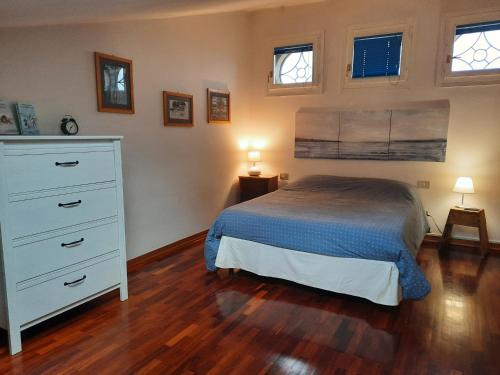 a bedroom with a bed and a dresser and two windows at Cà Rossa in Imola