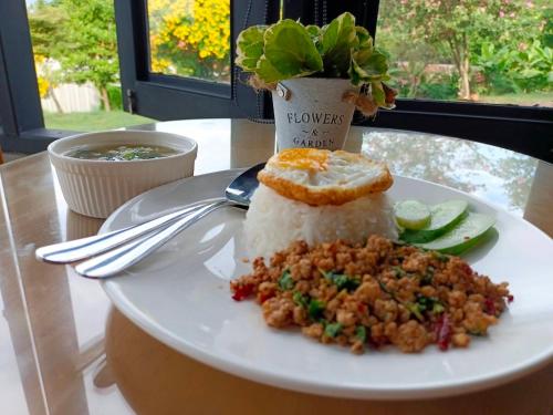 a plate with rice and food on a table at The Sunnery Ville in Lom Kao