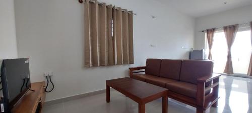 a living room with a couch and a coffee table at Tranquil Serviced Apartments - Sarjapur in Bengaluru