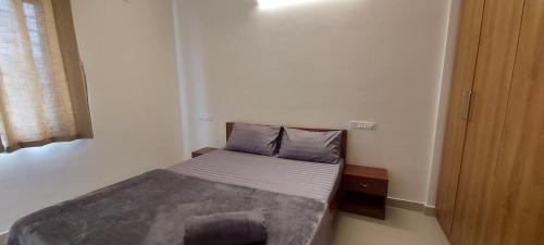a small bedroom with a bed in a room at Tranquil Serviced Apartments - Sarjapur in Bengaluru