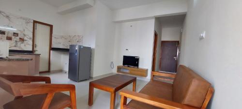 a kitchen with chairs and a table and a refrigerator at Tranquil Serviced Apartments - Sarjapur in Bengaluru