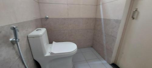 a bathroom with a white toilet in a stall at Tranquil Serviced Apartments - Sarjapur in Bengaluru