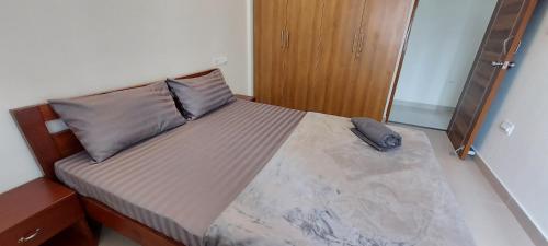 a bedroom with a large bed with a pillow on it at Tranquil Serviced Apartments - Sarjapur in Bengaluru