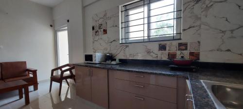 a kitchen with a counter and a sink and a window at Tranquil Serviced Apartments - Sarjapur in Bengaluru