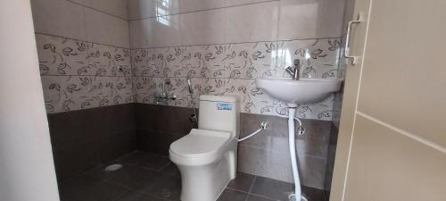 a bathroom with a toilet and a sink at Tranquil Serviced Apartments - Sarjapur in Bengaluru